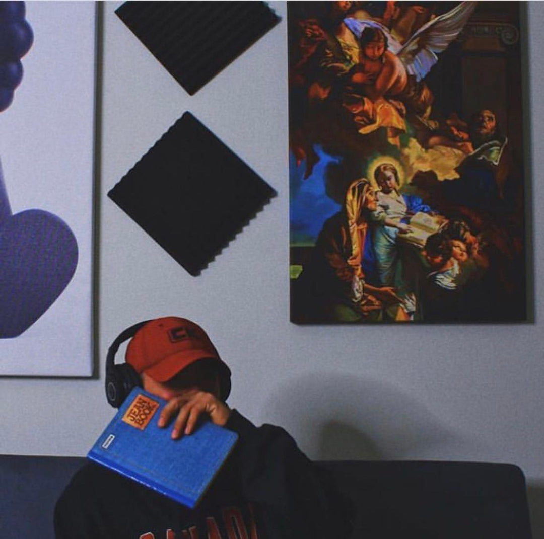 a man sitting on a couch in front of a painting 